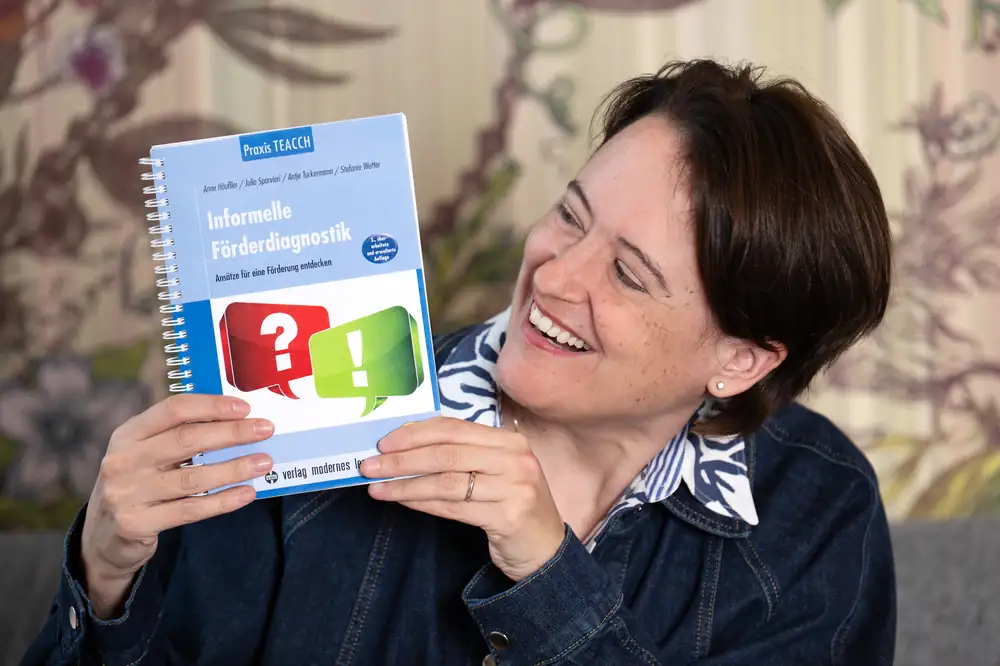 Kathy Reinaerts mit TEACCH®-Buch, lachend